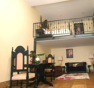 a living room with a balcony and a table and chairs at Grand Studio 56 in Faro