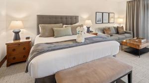 a bedroom with a large bed and a living room at 374 Lodge At Spruce Peak Ski In Ski In Ski Out King Studio By Stowe Mountain Rentals in Stowe