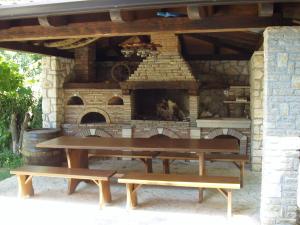a picnic table and benches in front of a brick oven at Guest House Renata in Plomin +48 photos