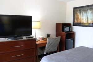 Una habitación de hotel con una cama y un escritorio con televisión. en Budget inn, en Greenville