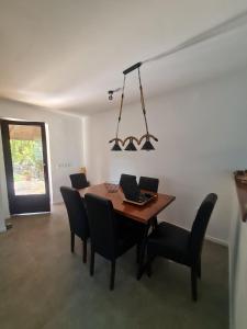 a dining room table with chairs and a laptop on it at Odmor pored Drine in Jovići