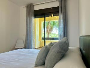 a bedroom with a bed and a large window at Duquesa Village Property in Manilva +34 photos