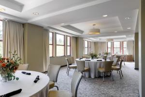 a conference room with tables and chairs and windows at Colcord Hotel Oklahoma City, Curio Collection by Hilton in Oklahoma City