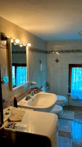 a bathroom with two toilets and a sink and a mirror at I Tigli in Sellano +35 photos