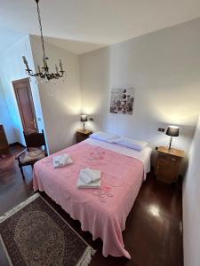 a bedroom with a pink bed with two towels on it at I Tigli in Sellano