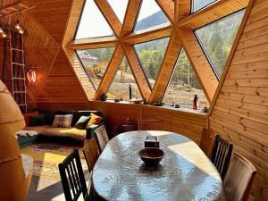 a dining room with a table and a large window at Domul Poarta Retezat in Rausor