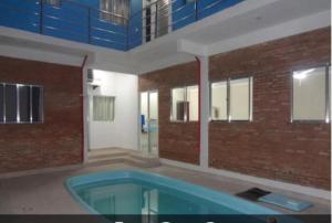 a building with a swimming pool in front of a building at Pousada PG One in Praia Grande