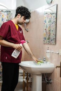 a man washing a sink in a bathroom at Borgo Insieme in San Donato Val di Comino