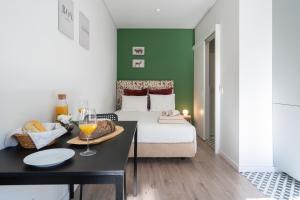 una camera con letto e tavolo con bicchieri da vino di Oporto Seaside Village - Casa Bosque a Matosinhos Altre 28 foto