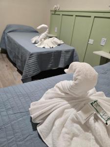 een kamer met 2 bedden en witte handdoeken. bij Nova Hotel Boutique in Villa Carlos Paz