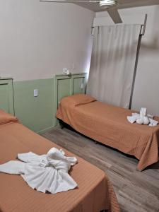 a room with two beds with towels on the floor at Nova Hotel Boutique in Villa Carlos Paz +30 photos