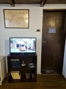 ノヴィサドにあるPassage 23のテレビとテレビ台のあるドアのある部屋