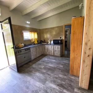 a kitchen with stainless steel appliances and a tile floor at Cabaña en Villa del Deportista Villa Shalom in Necochea
