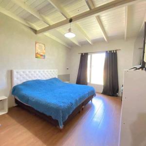 a bedroom with a bed with a blue blanket at Cabaña en Villa del Deportista Villa Shalom in Necochea