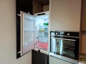 an empty refrigerator with its door open in a kitchen at Apartman Divna in Ljubuški