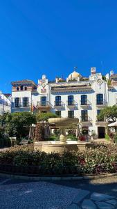 a large white building with a fountain in front of it at Loving Mediterranean Home in Estepona +30 photos