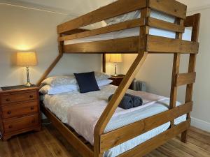 a wooden bunk bed in a bedroom with two lamps at Seacroft Estate in Apollo Bay