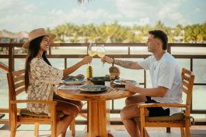 un homme et une femme assis à une table avec un verre de vin dans l'établissement Palafitos Overwater Bungalows, Catamarán, Cenote, All & More Inclusive - Adults Only, à Playa del Carmen 23 autres photos