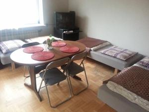 ピアセチュノにあるGreen Country Hostelのテーブル、椅子4脚、ソファが備わる客室です。
