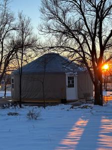 a house in the snow with the sun setting behind it at Apt 5 - High Plains Lodge at Nomad Landing in Clayton