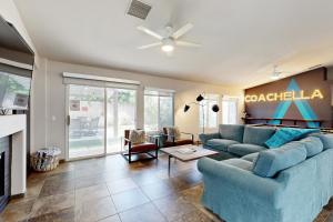 a living room with a blue couch and a fireplace at Deerbrook Manor Permit# 67085 in La Quinta