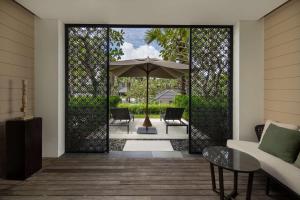 a living room with an open door with an umbrella at Radisson Blu Bali Uluwatu in Uluwatu