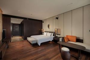a hotel room with a bed and a couch at Radisson Blu Bali Uluwatu in Uluwatu
