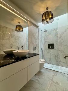 ein Badezimmer mit zwei Waschbecken und einer Dusche in der Unterkunft Exclusive Luxury Villa with S-pool & Garden in Porto