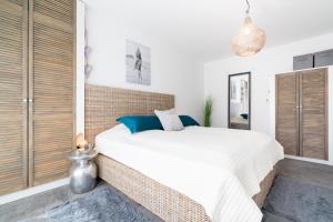 a bedroom with a large white bed and wooden cabinets at Paddel Nr 5 in Neustadt in Holstein