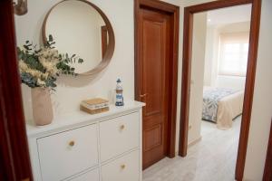 a bathroom with a white dresser and a mirror at Preto do Mar in Corcubión