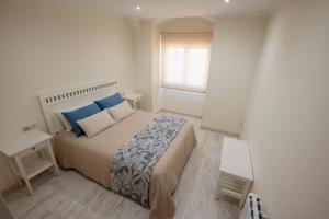 a small bedroom with a bed and a window at Preto do Mar in Corcubión