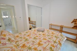 a bedroom with a bed with a colorful comforter at The Crab Shack - Kalbarri, WA in Kalbarri +6 photos