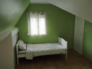 Una habitación verde con una cama y una ventana. en L'échappée belle 95, en Goussainville 2 fotos más