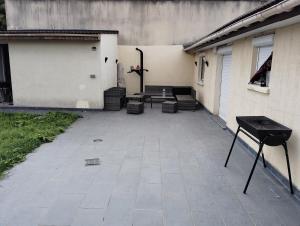 un patio con sillas y una mesa en un edificio en L'échappée belle 95, en Goussainville