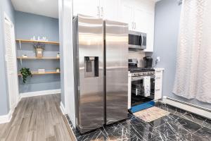 a stainless steel refrigerator in a kitchen next to a stove at New Apartment Liberty State Park Jersey City NJ Airport Train Manhattan NYC in Jersey City