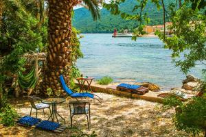 une plage avec une table et des chaises à côté d'un lac dans l'établissement Secluded fisherman's cottage Ston - Supavao, Peljesac - 9485, à Ston