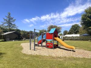 a playground with a slide in a park at Libelle in Hulshorst
