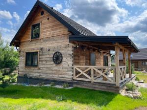 a log cabin with a black roof at Siedlisko Rykowisko in Radziwiłłówka