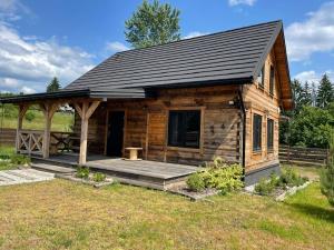 a log cabin with a porch and a roof at Siedlisko Rykowisko in Radziwiłłówka +15 photos