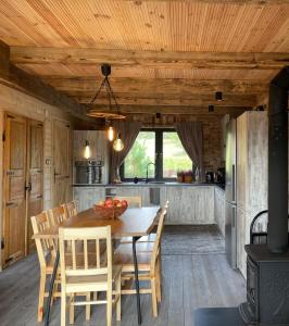 a kitchen and dining room with a wooden table and chairs at Siedlisko Rykowisko in Radziwiłłówka