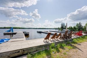 un grupo de sillas sentadas en un muelle en un lago en Love of Lake Cecebe #7 - Maijac Resort & Marina, en Burks Falls
