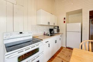 Una cocina blanca con estufa y refrigerador. en Love of Lake Cecebe #7 - Maijac Resort & Marina, en Burks Falls