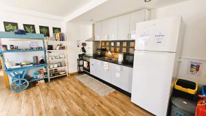 a kitchen with a white refrigerator and a wooden floor at Atlantic Spot Guest House in Praia de Mira