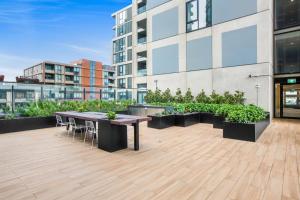 a patio with a table and chairs on a building at Chic 1-Bed with City Views Parking Gym & Pool in Melbourne