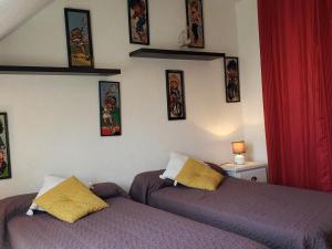 a bedroom with two beds and pictures on the wall at Maison cosy à Guérande, proche cité médiévale, avec jardin, terrasse, fibre et home cinéma. - FR-1-306-970 in Guérande