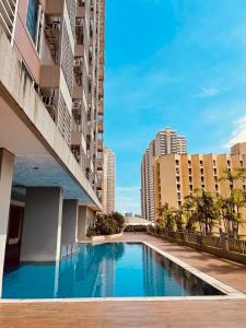 a swimming pool in the middle of a building with tall buildings at 8 Adriatico in Manila