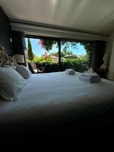 ein Schlafzimmer mit einem großen weißen Bett mit einem großen Fenster in der Unterkunft Exclusive Luxury Villa with S-pool & Garden in Porto