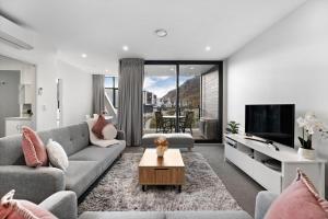 a living room with a couch and a tv at Haeata View in Queenstown