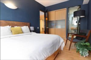 a bedroom with a large white bed and a desk at DOWNTOWN APT Pool & Gym in Mexico City +19 photos