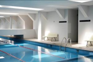 a swimming pool with two chairs next to it at DOWNTOWN APT Pool & Gym in Mexico City